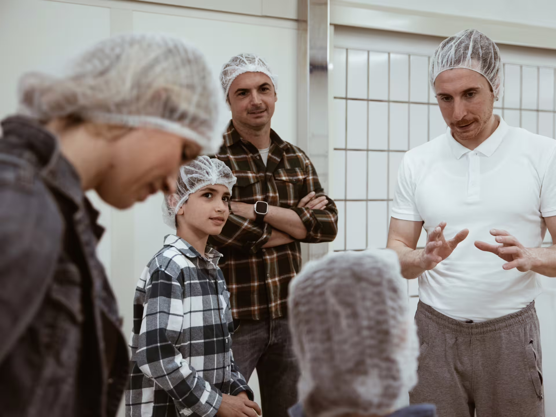 Group of visitors in hairnets learning about cheese-making at a traditional Isernia factory tour.