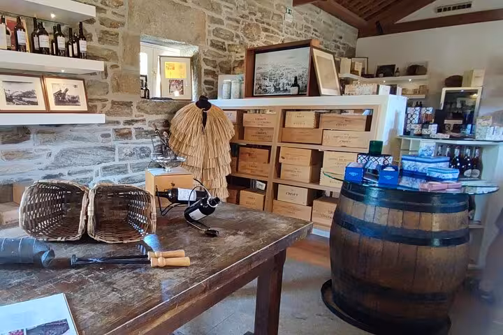 Traditional Douro wine cellar shop near Pinhão with barrels, bottles and rustic stone walls on Visit Pinhão