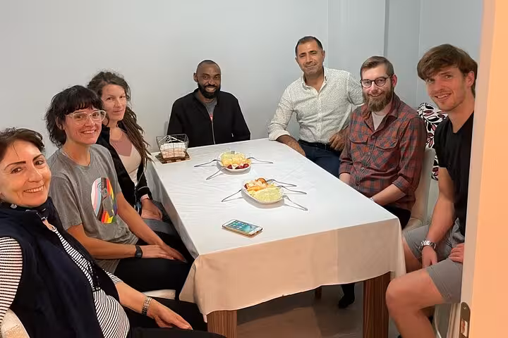 Small group seated with local hosts before a traditional family dinner in Istanbul, authentic home dining tour
