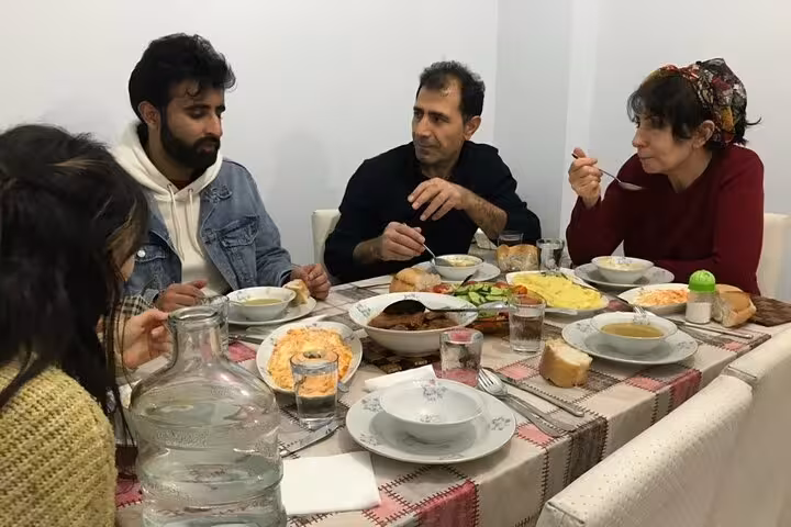 Traditional family dinner in Istanbul with local hosts, enjoying homemade Turkish soup, meze, and shared table talk