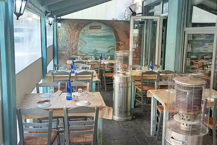 Cozy covered terrace dining area in a traditional local restaurant, set for a grilled meat tasting experience