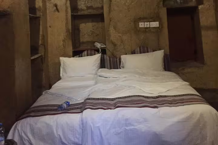 Cozy traditional room with twin beds in Nizwa, offering a glimpse into authentic Omani hospitality on a Muscat day tour.