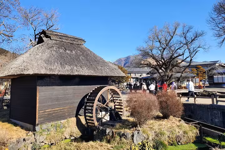 Traditional watermill in a quaint Japanese village near Mt. Fuji, showcasing cultural heritage and scenic landscapes.