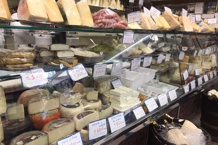 Cheese and cured meats on display in a traditional Trastevere deli for a food tour experience.