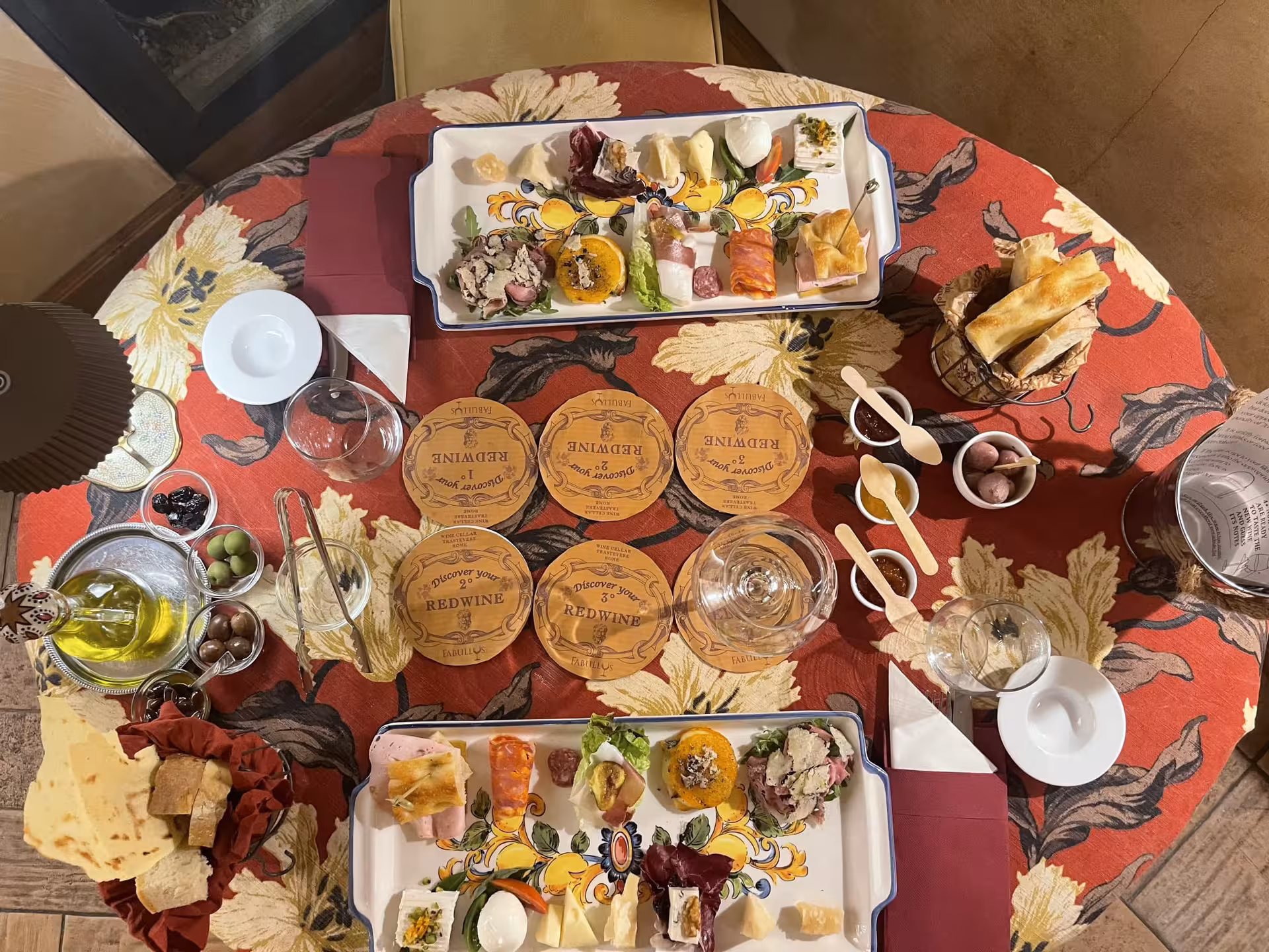 Elegant table setting with Italian appetizers and wine on a vibrant tablecloth in Trastevere tour.