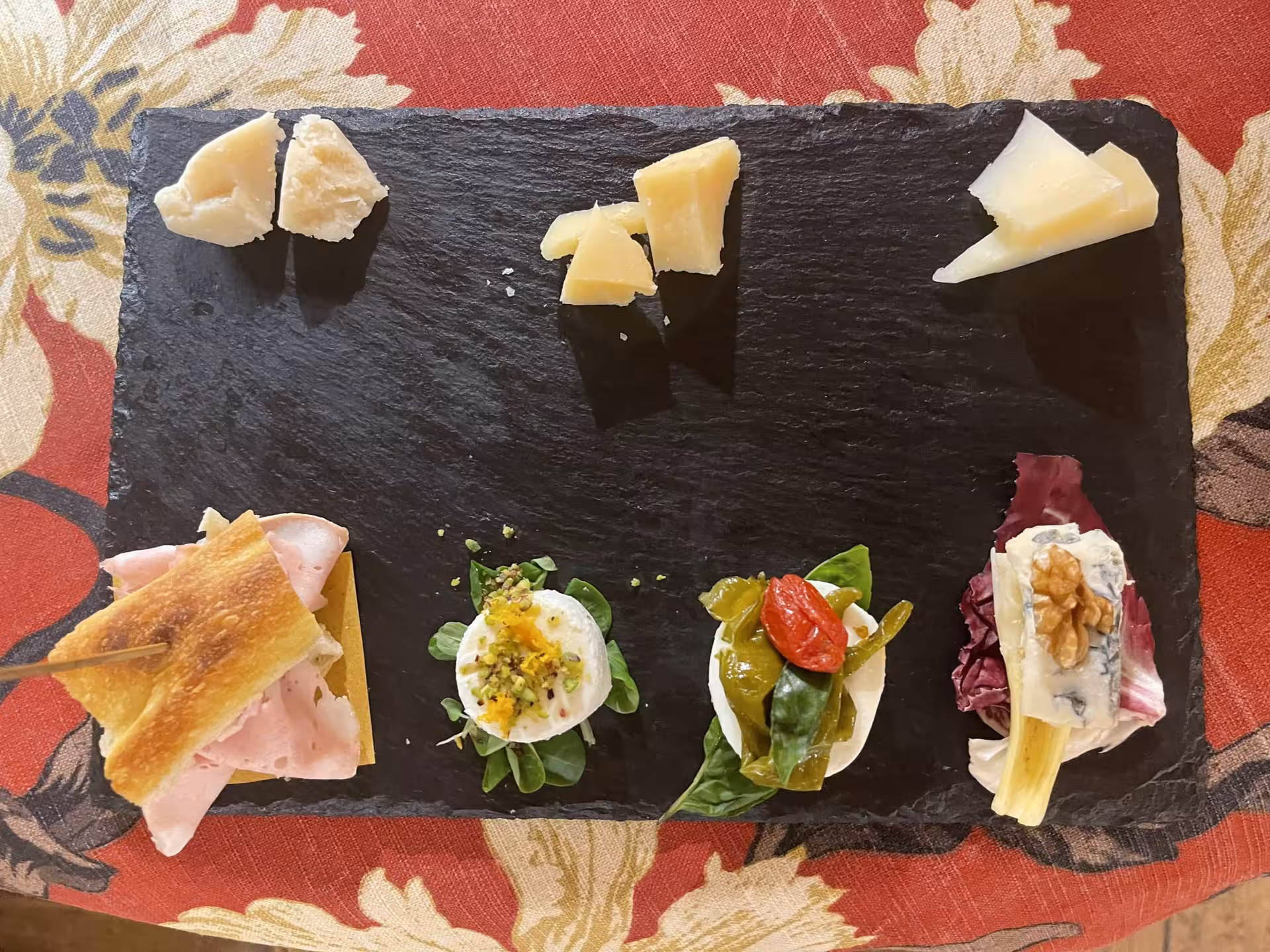 Artisanal Italian cheese and charcuterie platter on a slate, showcasing a variety of flavors for a Trastevere food tour.