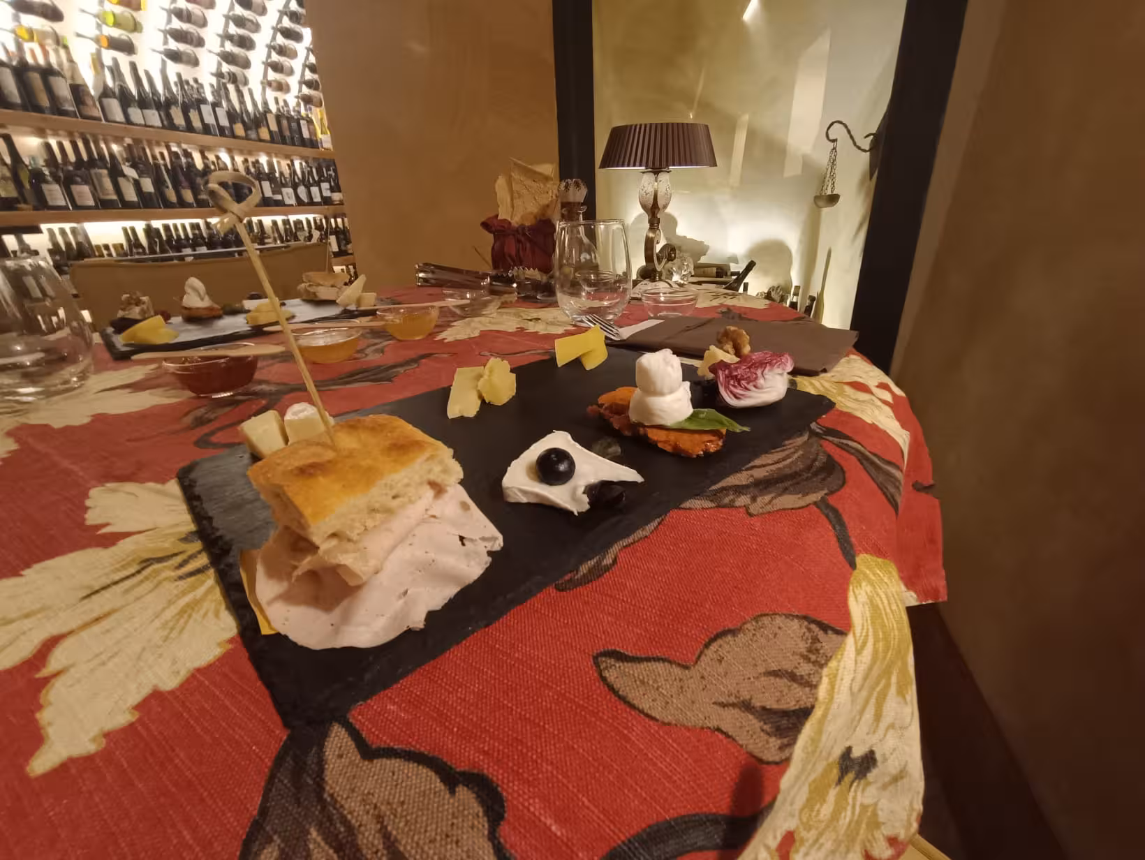 Gourmet platter with Italian deli meats and cheeses in a cozy Trastevere wine cellar setting.