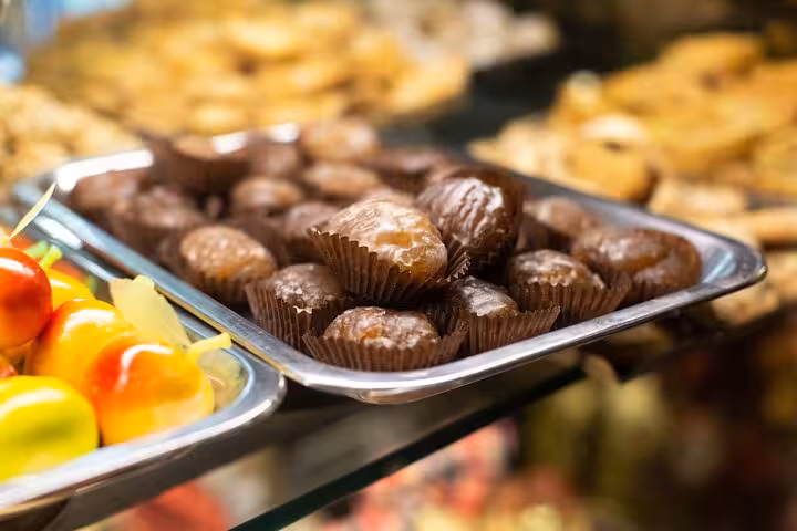 Close-up of assorted Italian pastries and candied fruits on a tray in a Trastevere food tour.