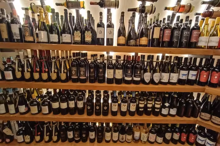 Wall of Italian wine bottles in a cozy Trastevere enoteca, featured on a Rome gourmet food and wine tasting tour