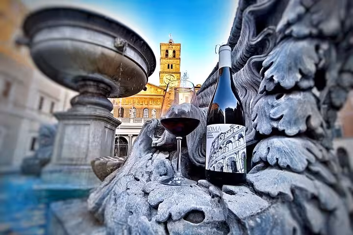 Glass of red wine and bottle by ornate stone fountain in Piazza di Santa Maria, Trastevere Rome wine tasting tour