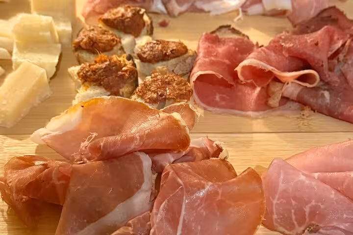 Selection of Italian cured meats and cheeses on a wooden board during a Trastevere Rome gourmet food and wine tour
