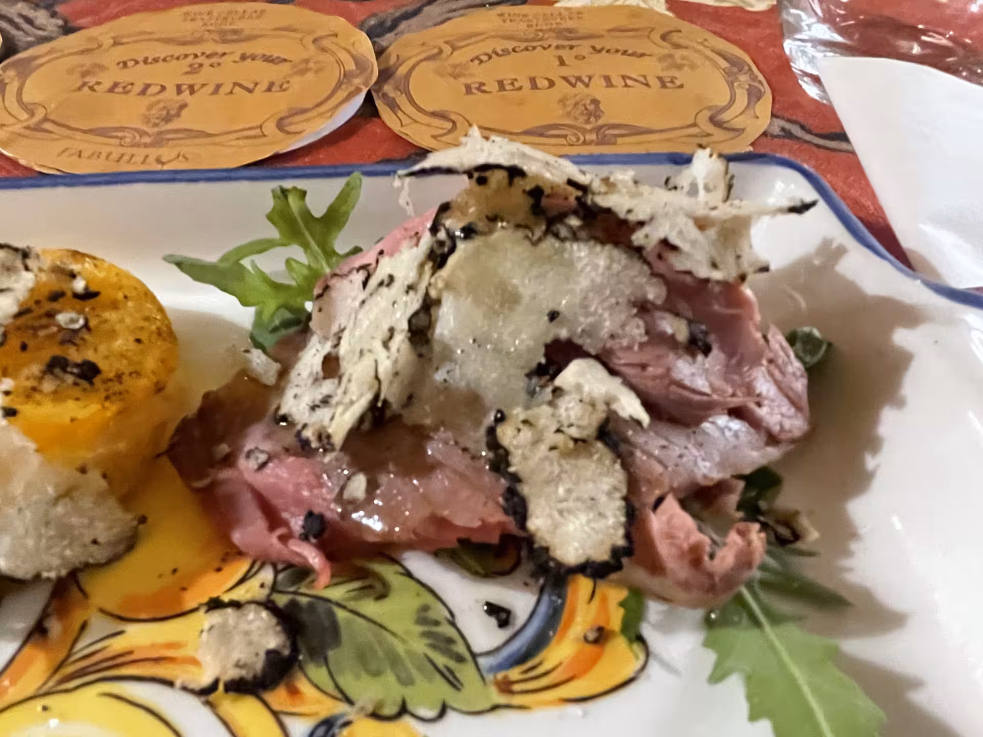 Savor exquisite truffle-topped beef on a vibrant plate, a highlight of the Trastevere Food & Wine Tour.