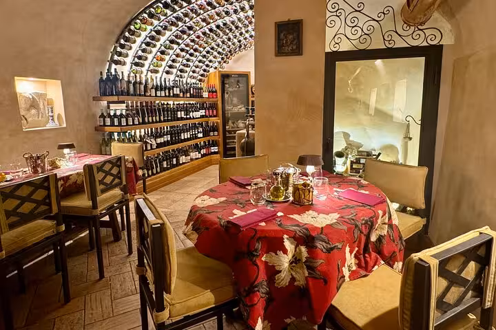 Cozy Trastevere wine cellar restaurant in Rome with arched bottle-lined walls and table set for a gourmet tasting