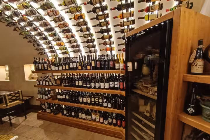 Atmospheric Trastevere wine cellar in Rome with arched ceiling and shelves filled with Italian red and white wine bottles