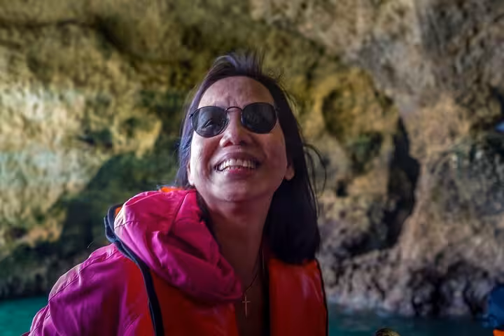 Smiling traveler in life jacket inside Benagil Cave during Algarve private tour from Lisbon boat trip