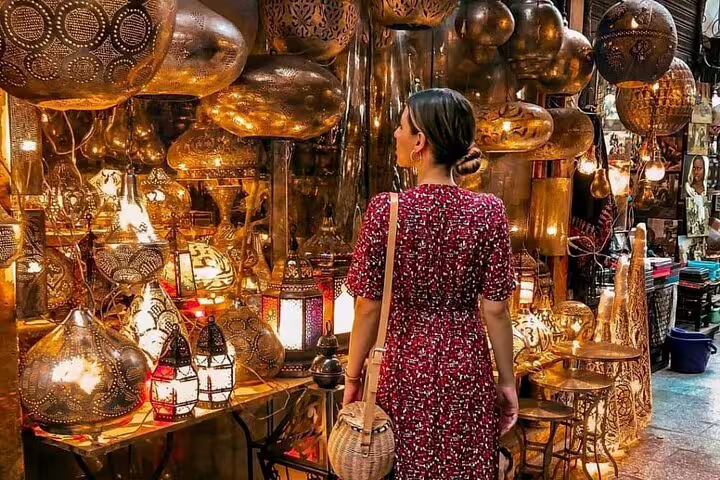 Traveler browsing glowing brass lanterns in Cairo bazaar on National Museum to Citadel & Bazaars tour