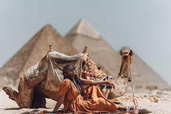 Traveler relaxing by camel at Giza Pyramids on Ultimate 3 Day Cairo tour with museum visit and free hostel