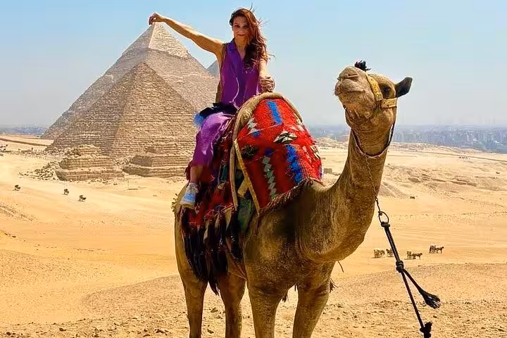 Traveler on camel posing by the Great Pyramid of Giza on VIP Giza & GEM tour with camel ride and Sphinx