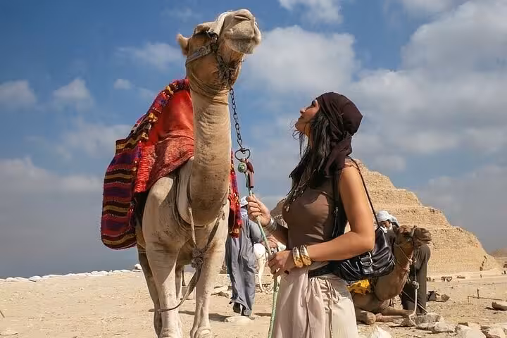 Traveler with camel beside the Step Pyramid at Saqqara on a Giza Pyramids Saqqara Memphis day tour