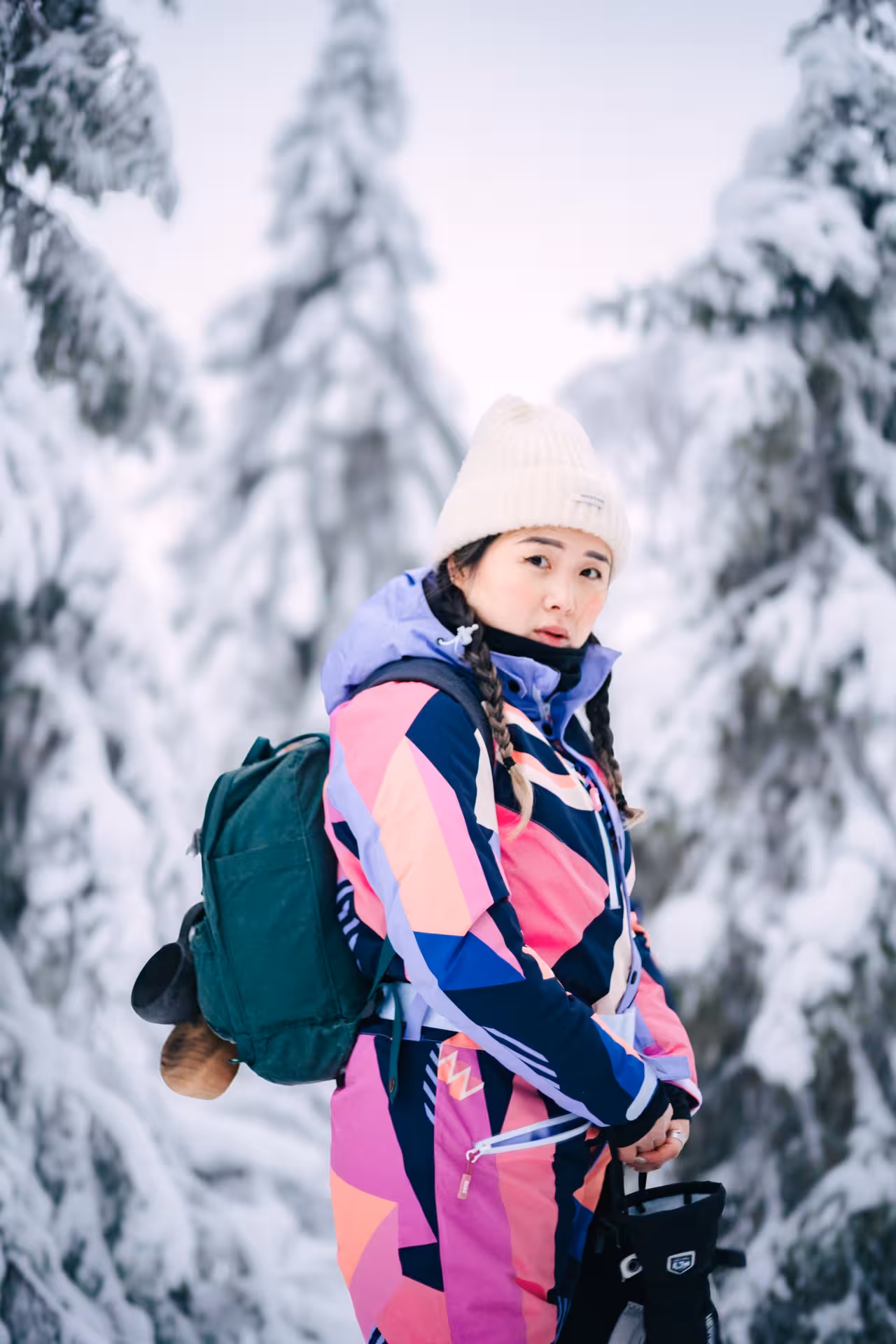 Traveler in colorful snowsuit enjoying snowy landscape during private photo session in Rovaniemi winter wonderland.