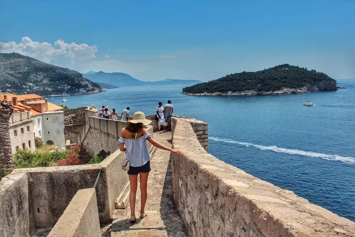 Traveler on Dubrovnik city walls overlooking the Adriatic and Lokrum Island on a private guided tour