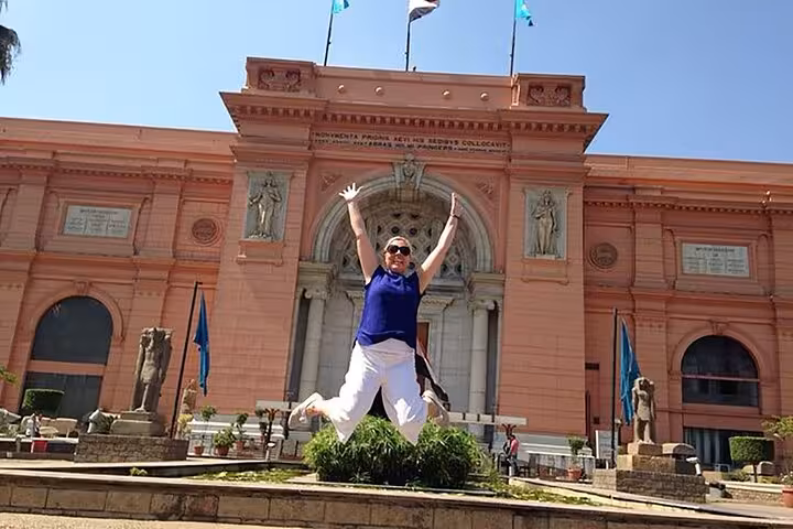 Traveler jumping at Egyptian Museum of Antiquities Cairo entrance, using online QR skip-the-line ticket entry