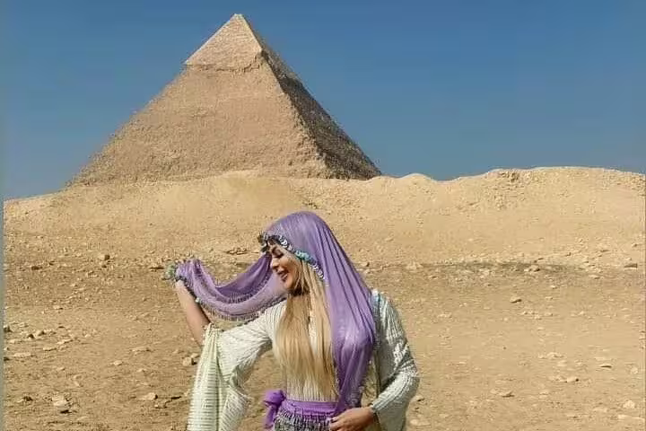 Traveler in purple scarf posing by Giza Pyramid on Cairo luxury tour to Memphis, Saqqara and Dahshur