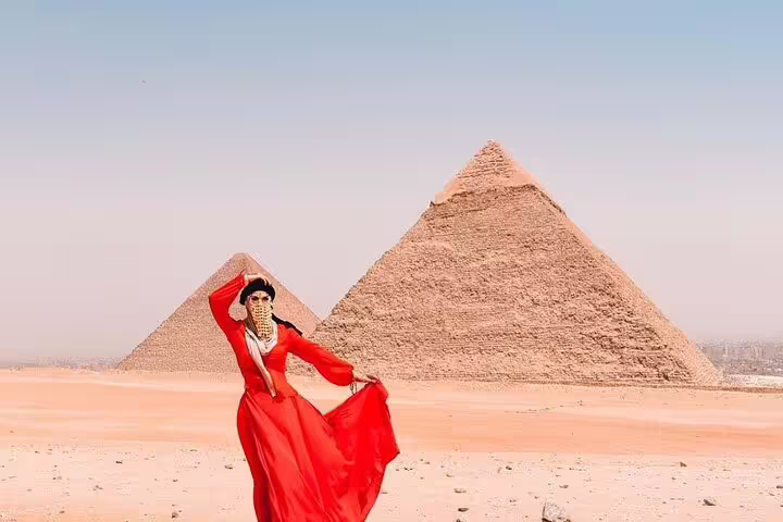 Traveler in red dress posing by the Giza Pyramids on Port Said day tour with Cairo sightseeing and lunch