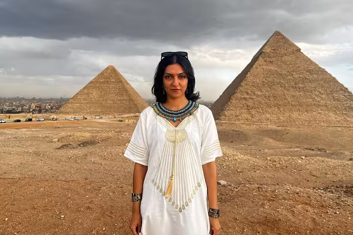 Traveler in traditional dress with Giza Pyramids backdrop on skip-the-line hidden gems tour for epic photos