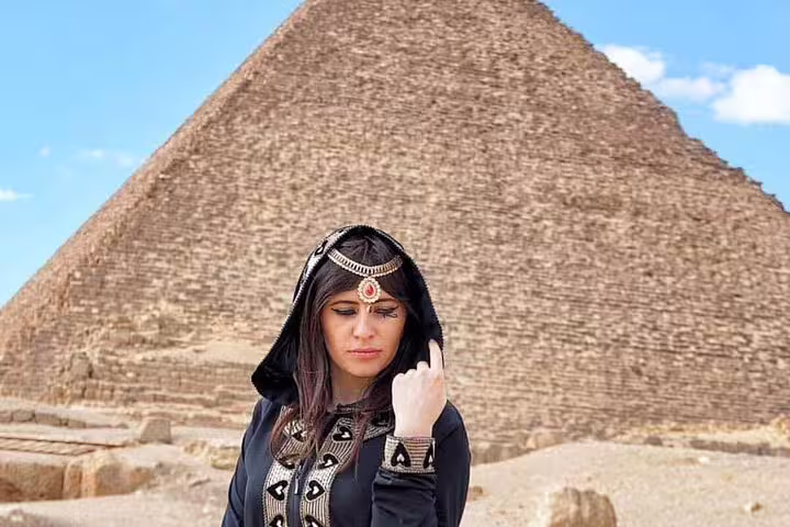 Traveler in traditional dress at the Great Pyramid of Giza on a Cairo full day tour from Alexandria by car