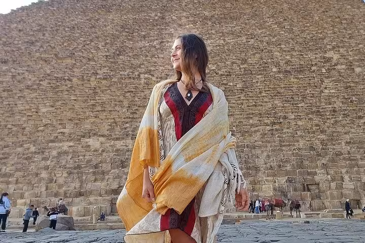 Traveler posing at the base of the Great Pyramid of Giza, must-see stop on Cairo 2-day tour package