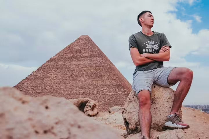 Traveler posing by the Great Pyramid of Giza on a 2-day private guided Cairo tour with Egyptologist