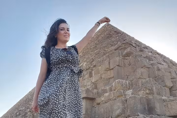Traveler posing beside the Great Pyramid of Giza on an all-inclusive guided Giza, Saqqara and Memphis tour