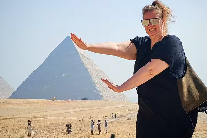 Traveler posing with the Great Pyramid of Giza during Grand Egyptian Museum and pyramids tour with lunch