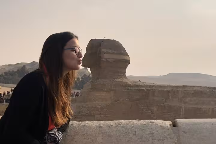 Traveler posing with the Great Sphinx of Giza on a private tour with pyramids and ATV desert ride