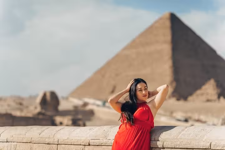 Traveler posing by the Great Sphinx with Giza Pyramid backdrop on half-day private guided tour in Cairo