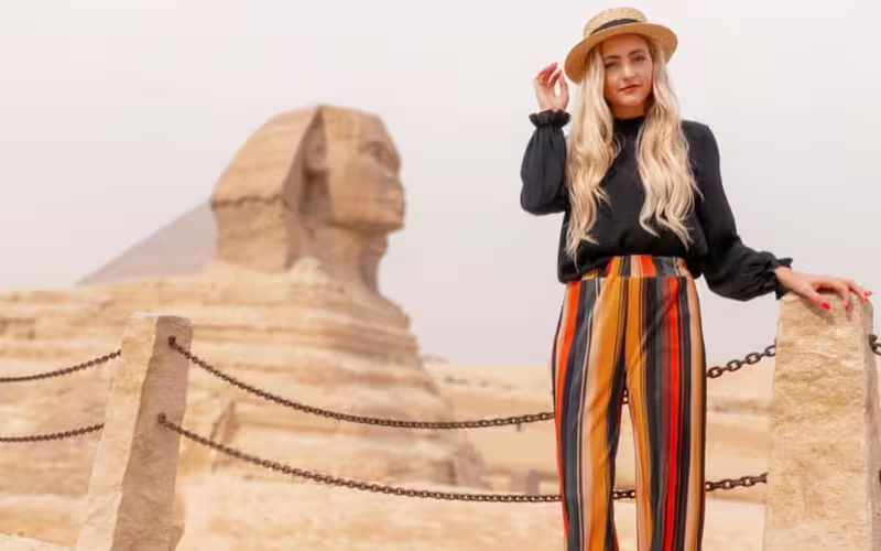 Traveler posing near the Great Sphinx at Giza during a pyramids full day tour with Cairo sightseeing stop