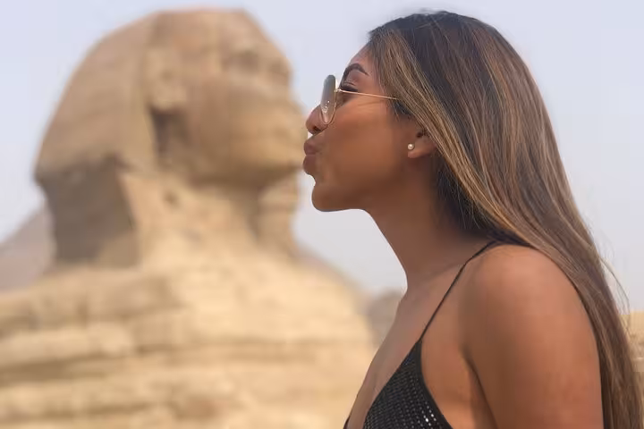 Traveler posing by the Great Sphinx of Giza on an all-inclusive guided Giza Pyramids tour from Cairo