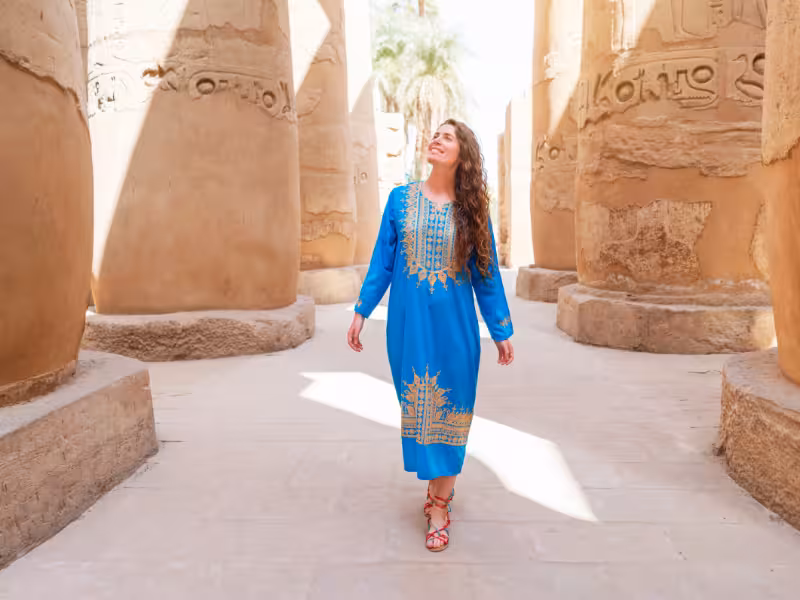 Traveler strolling among ancient stone columns at Jerash ruins, a highlight of the Timeless Jordan tour