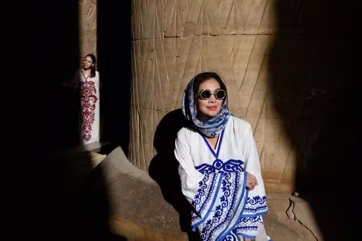 Traveler posing by carved stone column at Karnak Temple, Luxor, before the Sound and Light Show tour