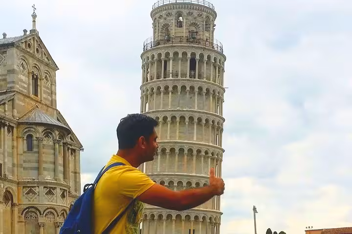 Traveler posing with a thumbs-up in front of the Leaning Tower of Pisa on the Pisa and Cinque Terre day trip from Florence.