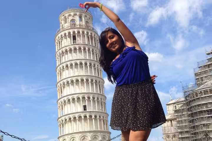 Traveler playfully interacting with the Leaning Tower of Pisa on a day trip from Florence to Pisa and Cinque Terre.