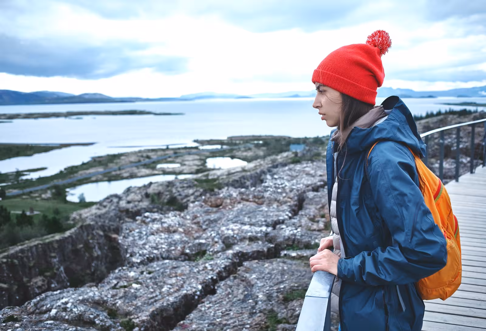 Traveler in a red beanie admires the scenic Icelandic landscape during the Northern Lights Hunt tour.