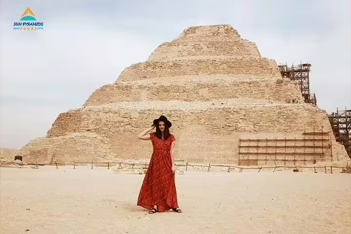 Traveler in red dress at Saqqara Step Pyramid, Egypt, on Sakkara and Memphis day tour from Cairo