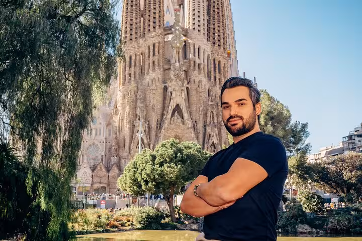 Portrait of a traveler with arms crossed before Sagrada Família, ideal for a pro Barcelona photoshoot in the Eixample.