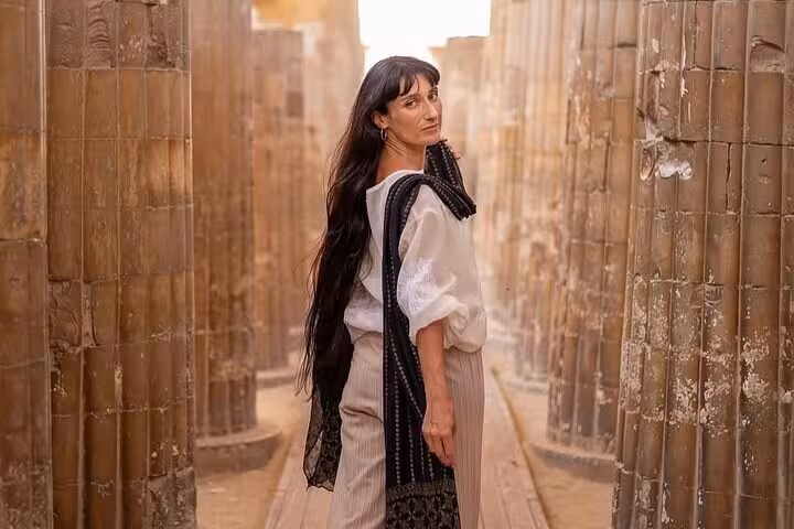 Traveler walking between ancient columns at Saqqara necropolis on Giza Pyramids Memphis day tour, Egypt