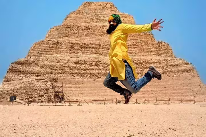 Traveler jumping in front of Saqqara Step Pyramid on Cairo luxury adventure tour to Memphis and Dahshur