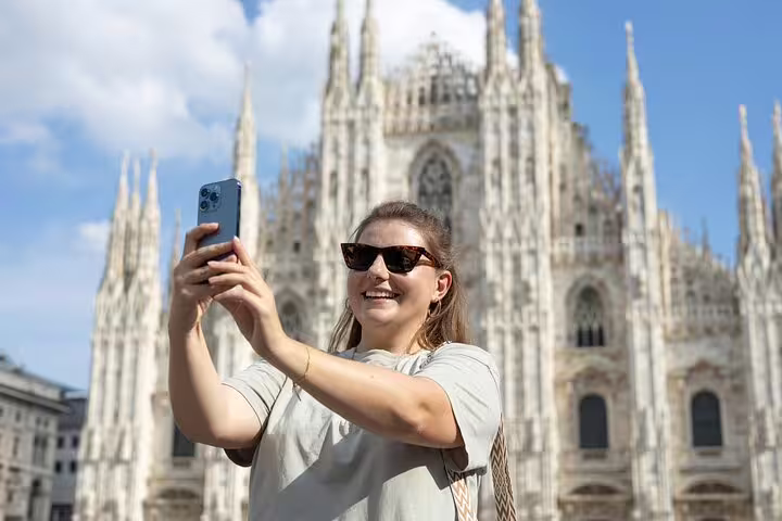 Smiling traveler taking a selfie in front of Milan Duomo during a guided private tour in the historic heart of the city