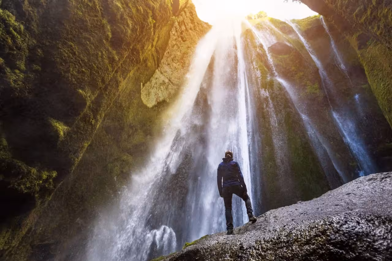 Traveler beneath Seljalandsfoss waterfall, South Coast Iceland highlight on Golden Circle and South Coast tour