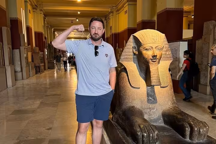 Traveler beside ancient Egyptian sphinx statue at Egyptian Museum, Cairo on private 3-day Giza tour